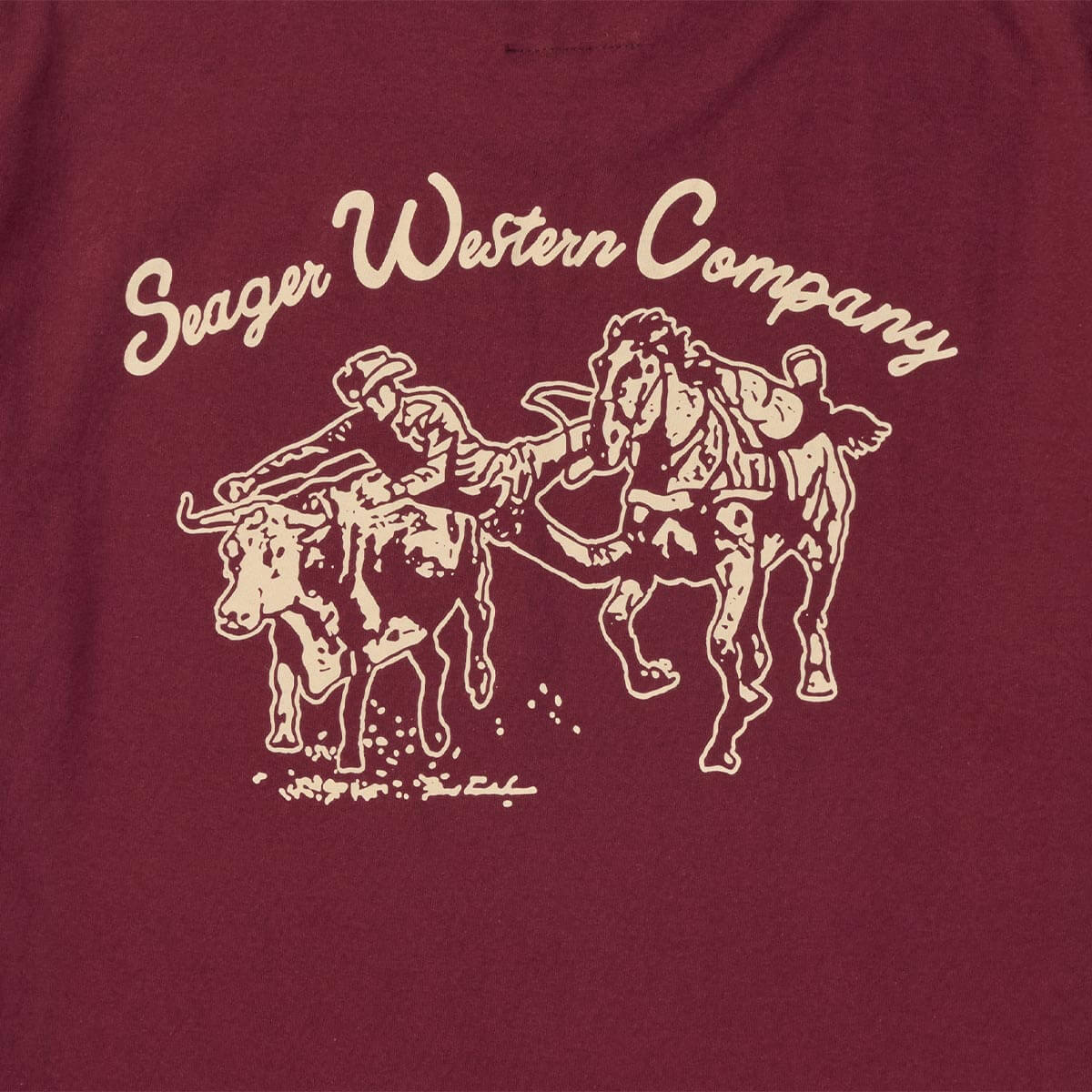 Maroon t-shirt with white graphic of a cowboy and horse chasing a steer, and 'Seager Western Company' text.